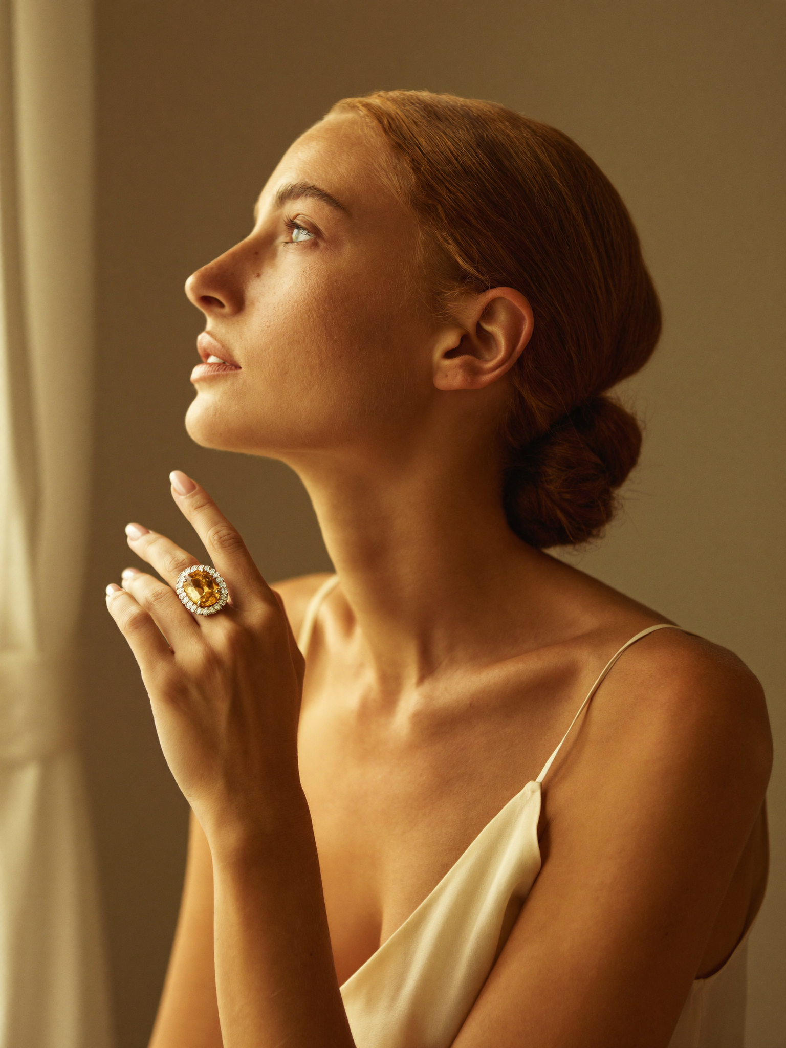 Modelo elegante de perfil com anel statement de citrino em halo de diamantes · ouro 18k JLópez · luz dourada