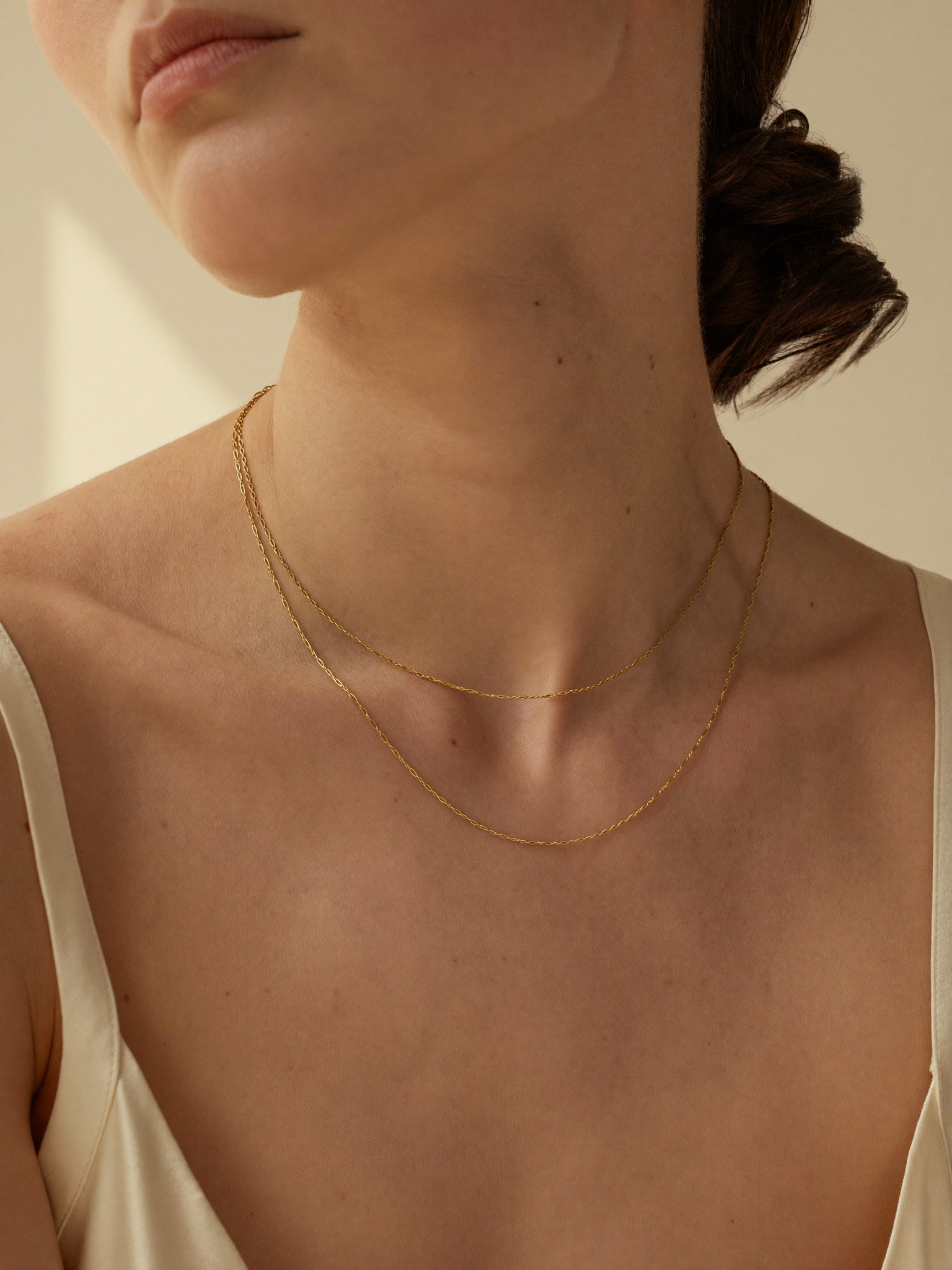 Layering de duas correntes finas em ouro 18k JLópez · veneziana + cordão delicado sobre o colo