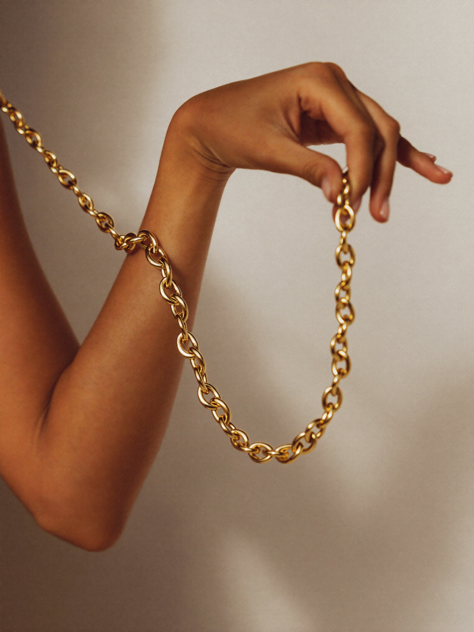 Mão segurando corrente cubana de ouro 18k JLópez · macro editorial Cartier